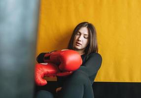 joven morena vestida de negro dedicada al entrenamiento de boxeo en el gimnasio del club de fitness foto