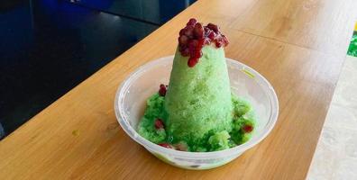 kakigori is Japanese shaved ice dessert , with red beans and sweet sauce on ice cream. Traditional summer dessert in Japan photo