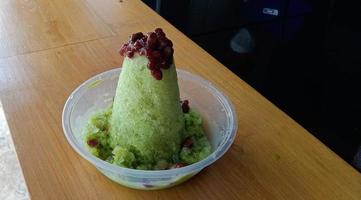 kakigori is Japanese shaved ice dessert , with red beans and sweet sauce on ice cream. Traditional summer dessert in Japan photo