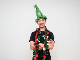 retrato, hombre asiático, camisa negra, cruz, brazo, feliz, sonrisa, con, sombrero verde, y, borla, colorido, celebración, feliz año nuevo, concepto foto