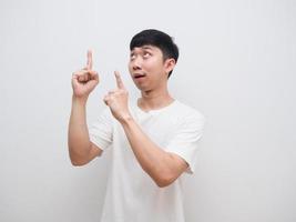 Asian man white shirt cheerful face point double finger up and look up on white background photo