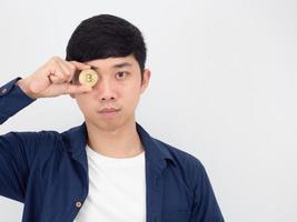 Closeup handsome man holding bitcoin close his eye confident face looking at camera on white background photo