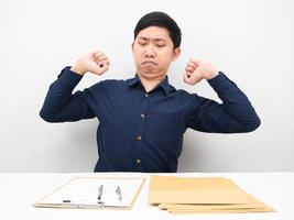 Businessman sitting at his workplace stretch oneself feeling lazy to working photo