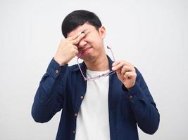 Man take off his glasses and feeling tried touch his eyes,Asian man pain his eyes from working photo