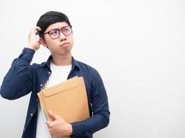 Man wearing glasses holding envelope feeling doubt looking at copy space photo