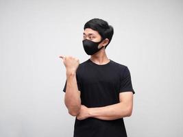 Portrait man wearing mask point finger and looking at left side on white background photo