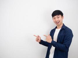 Handsome man point double finger left side with happy smile looking at camera on white isolated background photo