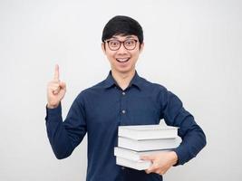 hombre asiático con gafas apuntar con el dedo hacia arriba obtener idea sosteniendo libro empresario concepto fondo blanco foto