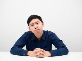 Man sitting and feeling serious looking at you white background' photo