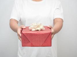 Woman hand giving red gift box white background crop shot photo