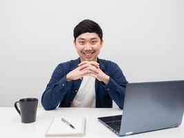 el hombre de negocios se sienta a trabajar en el escritorio con una sonrisa, el hombre se sienta en el lugar de trabajo foto