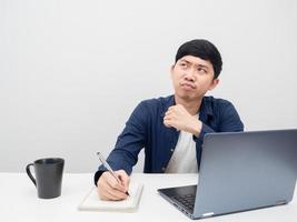 Asian man working at workplace feeling bored and looking at copy space photo