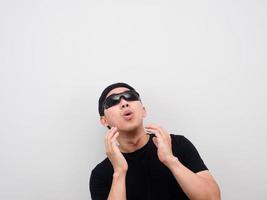 Man wearing sunglasses feeling amazed  looking up at copy space white background photo