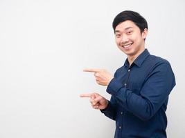 Asian man happy emotion gesture point finger at copy space white background photo