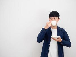 Handsome man drinking coffee cup and looking at copy space side on white background photo