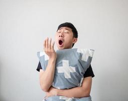 Asian man wake up and hugging pillow yawn and feel sleepy on white isolated,Lazy concept photo