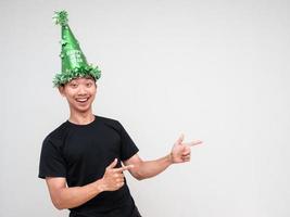 Young man happy face with green hat and point double finger at right look at camera and smile on white isolated background photo
