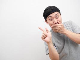 Man grey shirt gesture point finger at copy space with close mouth cheerful emotion photo