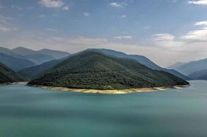 paisaje del lago del embalse de zhinvali paisaje con montañas a lo largo de la cordillera principal del cáucaso en georgia. foto