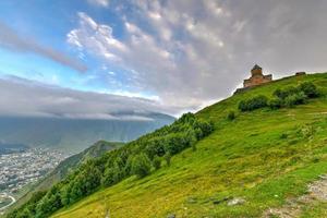 iglesia de la trinidad de gergeti, iglesia de la santísima trinidad cerca del pueblo de gergeti en georgia, bajo el monte kazbegi. foto