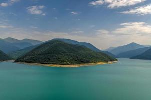 paisaje del lago del embalse de zhinvali paisaje con montañas a lo largo de la cordillera principal del cáucaso en georgia. foto