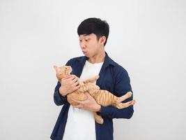 hombre asiático guapo con un gato encantador en la mano sobre fondo blanco foto