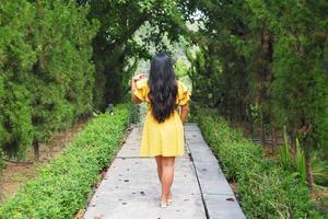 traveler woman yellow dress with forest background photo