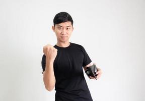 Young man black shirt show fist up feel confident at face with cash in wallet in hand look at camera on white isolated background photo