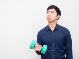 Man lazy emotion holding dumbbell looking at copy space photo