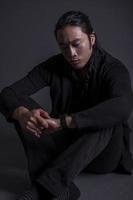 Guapo hombre asiático de moda posando en el estudio sobre fondo negro, concepto de estilo de vida de la gente moderna foto