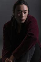 Guapo hombre asiático de moda posando en el estudio sobre fondo negro, concepto de estilo de vida de la gente moderna foto