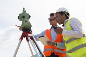 Surveyor engineer is measuring level on construction site. Surveyors ensure precise measurements before undertaking large construction projects. photo
