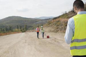 Surveyor engineer is measuring level on construction site. Surveyors ensure precise measurements before undertaking large construction projects. photo