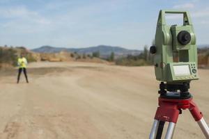 el ingeniero topógrafo está midiendo el nivel en el sitio de construcción. los topógrafos aseguran mediciones precisas antes de emprender grandes proyectos de construcción. foto