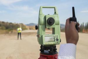 Surveyor engineer is measuring level on construction site. Surveyors ensure precise measurements before undertaking large construction projects. photo