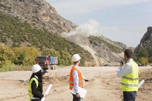 el ingeniero topógrafo está midiendo el nivel en el sitio de construcción. los topógrafos aseguran mediciones precisas antes de emprender grandes proyectos de construcción. foto