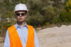 el ingeniero topógrafo está midiendo el nivel en el sitio de construcción. los topógrafos aseguran mediciones precisas antes de emprender grandes proyectos de construcción. foto