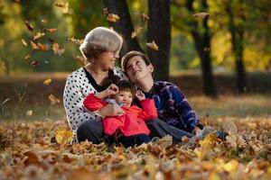 happy grandmother, granddaughter and grandson playing in the park photo