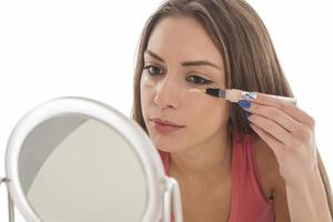 belleza maquillaje mujer sonriendo primer plano. bella joven aplicando maquillaje con rubor foto