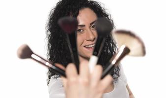 Closeup portrait of woman with makeup brush near face photo