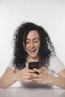 Portrait of a happy woman using mobile phone isolated over white background photo