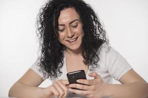 Portrait of a happy woman using mobile phone isolated over white background photo