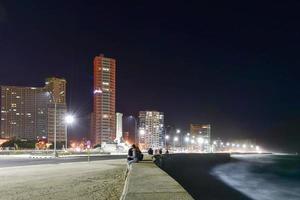 The Malecon in Havana at night. It is a broad esplanade, roadway and seawall which stretches for 8 km along the coast in Havana, Cuba photo