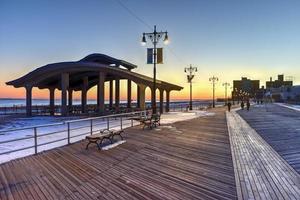 paseo marítimo de coney island con salto en paracaídas en el fondo en coney island, ny. el malecón fue construido en 1923 y se extiende por 2.51 millas foto