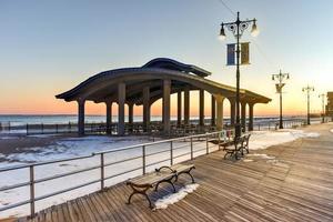 paseo marítimo de coney island con salto en paracaídas en el fondo en coney island, ny. el malecón fue construido en 1923 y se extiende por 2.51 millas foto