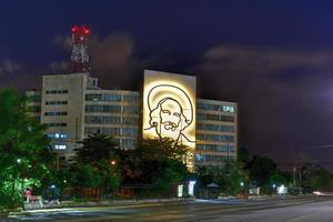 Portrait of Camilo Cienfuegos on the Ministry of Informatics and Communications on Plaza de la Revolucion in Havana, Cuba at night, 2022 photo