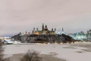 Parliament Hill and the Canadian House of Parliament in Ottawa, Canada during wintertime at night. photo