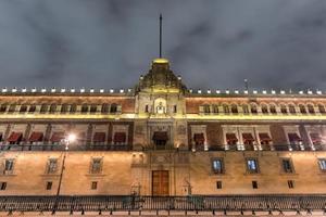 palacio nacional iluminado en la plaza de la constitución de la ciudad de méxico por la noche. foto