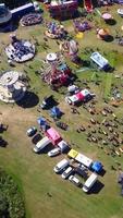 Luftaufnahmen eines Jahrmarkts, die Menschen genießen den heißen Sommer in einem örtlichen öffentlichen Park der Stadt Luton, es wurde ein Jahrmarkt mit gruseligen Fahrgeschäften für Familien abgehalten. video