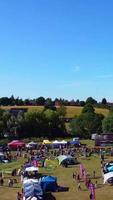 Luftaufnahmen eines Jahrmarkts, die Menschen genießen den heißen Sommer in einem örtlichen öffentlichen Park der Stadt Luton, es wurde ein Jahrmarkt mit gruseligen Fahrgeschäften für Familien abgehalten. video